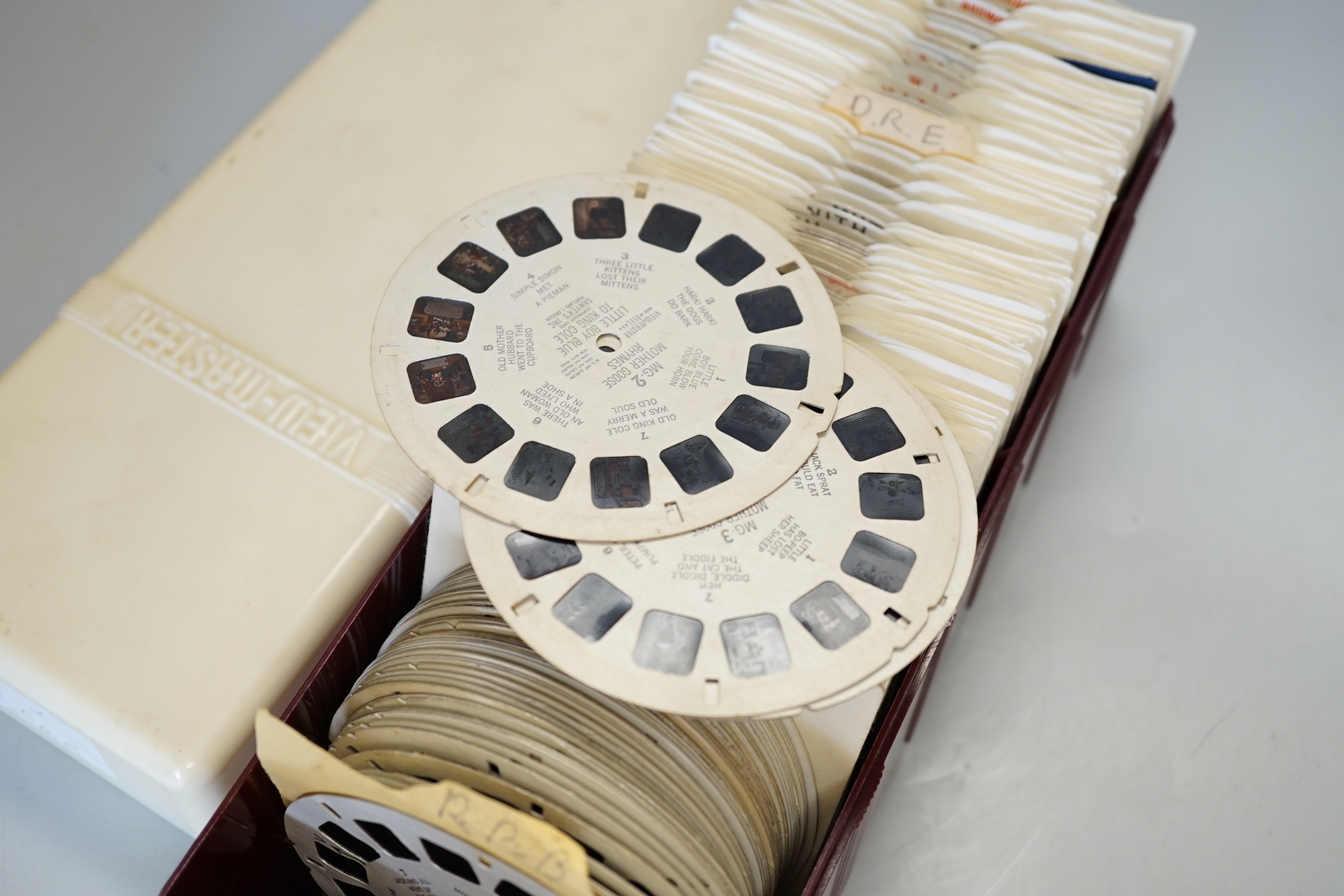 A large collection of View-Master reels contained within six plastic View-Master boxes, subjects include scenes from the United States, Charlie Brown, Bambi, Rin-Tin-Tin, etc.